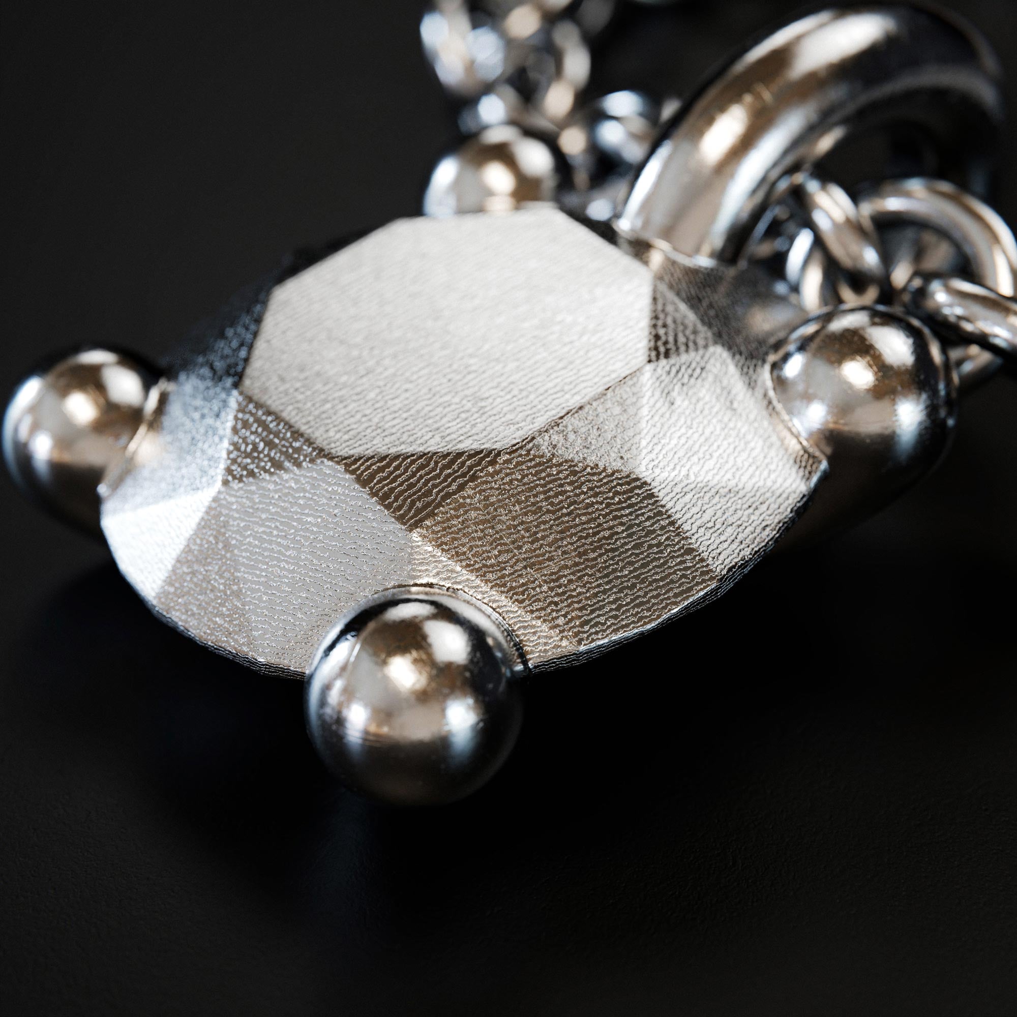 Detail view of the handmade small platinum brilliant charm from the LOST collection by OFFFHAND. Designed by Michael Rüscher.