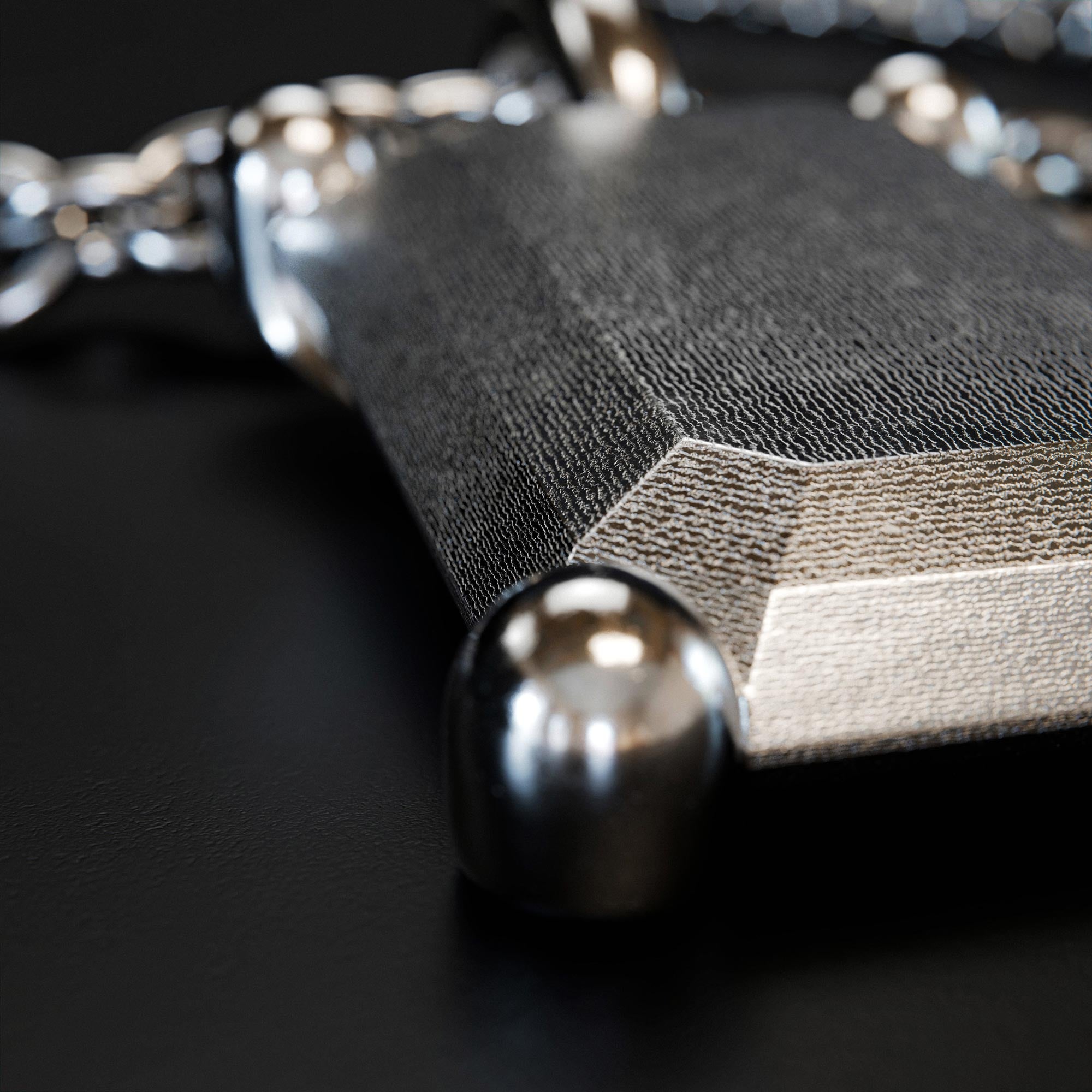Detail view of the handmade small platinum emerald charm from the LOST collection by OFFFHAND. Designed by Michael Rüscher.