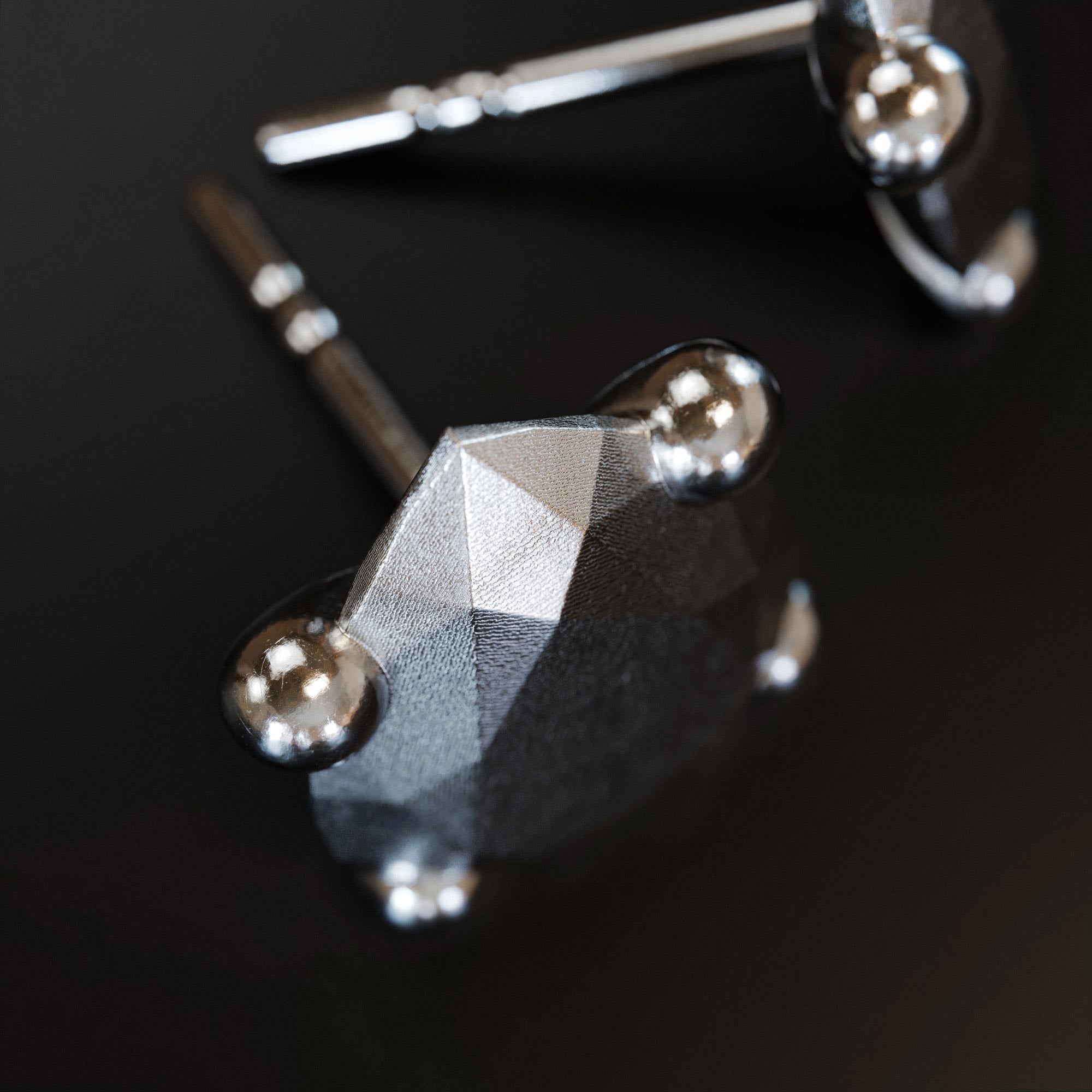 Detail view of the handmade small platinum pear earring from the LOST collection by OFFFHAND. Designed by Michael Rüscher.