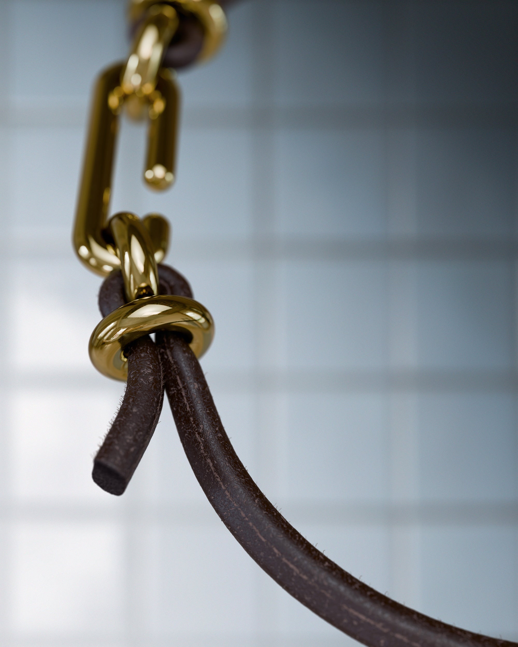 Detail of the handmade bracelet with leather dark band and gold clasp, from the BOND collection by OFFFHAND. Designed by Michael Rüscher.